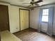 This bedroom features wood floors, a ceiling fan, closet and a window with curtains at 8875 N Goat Hollow Rd, Mooresville, IN 46158
