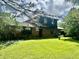 View of a beautiful brick two-story home with a well-manicured lawn and partial tree coverage at 8875 N Goat Hollow Rd, Mooresville, IN 46158