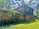 Multi-level home exterior with brick and dark-stained wood, surrounded by mature trees and a green lawn at 8875 N Goat Hollow Rd, Mooresville, IN 46158