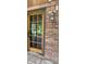 Glass panel front door with red brick, and an antique lantern lamp at 8875 N Goat Hollow Rd, Mooresville, IN 46158