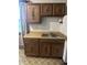 A kitchen area with wooden cabinets, countertop, sink, and patterned flooring at 8875 N Goat Hollow Rd, Mooresville, IN 46158