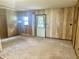View of the living room with carpet and wood paneling and a door to the exterior at 8875 N Goat Hollow Rd, Mooresville, IN 46158