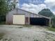 Metal outbuilding or barn featuring a roll-up door and open storage area at 8875 N Goat Hollow Rd, Mooresville, IN 46158