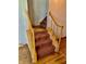 Carpeted staircase with wooden handrail and hardwood floors, leading to the upper level of the home at 8875 N Goat Hollow Rd, Mooresville, IN 46158