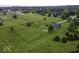 Spacious lot featuring a blue house, fenced backyard with lush green lawn, outbuilding and mature trees at 911 Centennial Rd, Martinsville, IN 46151