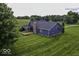 Picturesque aerial view of a blue house with a large yard and mature trees surrounding the property at 911 Centennial Rd, Martinsville, IN 46151