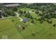 Vast property showcasing a blue house, red outbuilding, and sprawling fenced yard, surrounded by green fields at 911 Centennial Rd, Martinsville, IN 46151