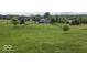 Sprawling backyard features lush grass, a fence, mature trees and a charming blue house at 911 Centennial Rd, Martinsville, IN 46151