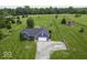 An aerial view shows a blue home with a large lawn, long driveway, and a detached red barn at 911 Centennial Rd, Martinsville, IN 46151