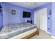 Bright bedroom features blue walls, a TV, and a double closet, offering a comfortable and functional living space at 911 Centennial Rd, Martinsville, IN 46151