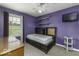Well-lit bedroom with a large window, storage shelves, and television creating a cozy and functional space at 911 Centennial Rd, Martinsville, IN 46151