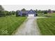 Charming blue home with a two-car garage, spacious yard, and a long gravel driveway at 911 Centennial Rd, Martinsville, IN 46151