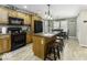 Kitchen featuring wood cabinets, black appliances, an island with seating, and hardwood floors at 911 Centennial Rd, Martinsville, IN 46151