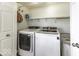 Bright laundry room with modern, front-loading washer and dryer and functional shelf space for storage at 911 Centennial Rd, Martinsville, IN 46151