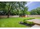 Huge lush backyard featuring a wooden shed and fully surrounded by a privacy fence at 9385 Helmsdale Dr, Indianapolis, IN 46256