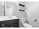 Well-lit bathroom features a modern vanity, toilet, and floating shelves for storage and decoration at 9385 Helmsdale Dr, Indianapolis, IN 46256