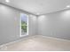 This bedroom is well-lit with plush carpet, light grey walls and a bright window at 9385 Helmsdale Dr, Indianapolis, IN 46256