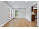 Open dining room with wood floors, large window, and views into the modern kitchen area at 9385 Helmsdale Dr, Indianapolis, IN 46256