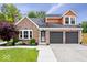 Charming brick home featuring a well-maintained lawn, complemented by a two-car garage and lovely front yard landscaping at 9385 Helmsdale Dr, Indianapolis, IN 46256