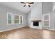 Spacious living room with a painted fireplace, wood floors, ceiling fan, and bright natural light at 9385 Helmsdale Dr, Indianapolis, IN 46256