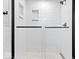 Elegant tiled shower with glass door and black hardware, providing a sleek and modern design at 9385 Helmsdale Dr, Indianapolis, IN 46256