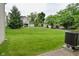 View of a well-maintained backyard with lush green lawn and mature trees at 9477 Aberdare N Dr, Indianapolis, IN 46250