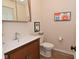 Well-lit powder room with floating wood vanity, modern faucet, and art at 9477 Aberdare N Dr, Indianapolis, IN 46250