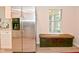 Stainless steel refrigerator and built-in bench seating in the kitchen, with a window view to the backyard at 9477 Aberdare N Dr, Indianapolis, IN 46250