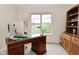 Bright office space with a wooden desk and a large window overlooking the yard at 9477 Aberdare N Dr, Indianapolis, IN 46250