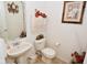 Cozy powder room with pedestal sink, decorative wall art, and a neutral color scheme at 10601 Adam Dr, Indianapolis, IN 46231
