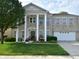 Charming two-story home features a columned porch, attached garage, and well-maintained lawn at 10601 Adam Dr, Indianapolis, IN 46231