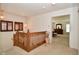 Hallway with wooden railing, vintage pendant lights, and view into a bedroom at 10601 Adam Dr, Indianapolis, IN 46231