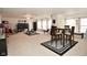 Open living area with neutral carpet, large TV, ceiling fan, and dining area at 10601 Adam Dr, Indianapolis, IN 46231