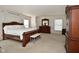 Large bedroom with dark wood furniture, white bedding, and sunlit windows at 10601 Adam Dr, Indianapolis, IN 46231