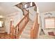Staircase with wooden banister leading upstairs, and features natural light and neutral carpeting at 10601 Adam Dr, Indianapolis, IN 46231