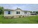 Charming single-story home with light siding, blue shutters, and a well-maintained front lawn and colorful flower bed at 10694 W Hickory Ct, Quincy, IN 47456