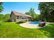Spacious backyard with a pristine in-ground pool, lush lawn, and mature trees, creating a serene outdoor oasis at 11059 W Old Nashville Rd, Columbus, IN 47201