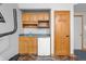 Basement features a built-in bar area, refrigerator, and a door to another room at 11059 W Old Nashville Rd, Columbus, IN 47201
