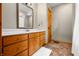 Bathroom featuring wood vanity, vanity mirror, and tiled floors with a patterned rug at 11059 W Old Nashville Rd, Columbus, IN 47201