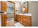 Well-lit bathroom features a wooden vanity, sink, and a glimpse of the home's upper level at 11059 W Old Nashville Rd, Columbus, IN 47201