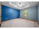 Bedroom with a tray ceiling, carpet floors, and bright natural light from a window at 11059 W Old Nashville Rd, Columbus, IN 47201