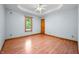 Bright bedroom with hardwood floors, window, and a tray ceiling with ceiling fan at 11059 W Old Nashville Rd, Columbus, IN 47201