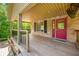 Spacious covered front porch with wood flooring and railing, perfect for relaxing at 11059 W Old Nashville Rd, Columbus, IN 47201