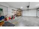 Spacious garage with high ceilings, roll up door, workbench, storage shelving, and ample space for vehicles at 11059 W Old Nashville Rd, Columbus, IN 47201