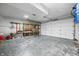 Spacious garage with high ceilings, roll up door, workbench, storage shelving, and ample space for vehicles at 11059 W Old Nashville Rd, Columbus, IN 47201