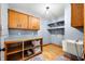 Well-lit laundry room with blue walls, wooden cabinets, folding counter, a utility sink, and storage shelves at 11059 W Old Nashville Rd, Columbus, IN 47201
