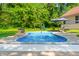 Backyard in-ground pool and patio with a backdrop of lush trees, and a lawn area with a swing set at 11059 W Old Nashville Rd, Columbus, IN 47201
