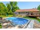 Inviting in-ground pool on a sunny day, complemented by a spacious patio, backyard, and a glimpse of the charming home exterior at 11059 W Old Nashville Rd, Columbus, IN 47201