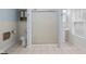 Full bathroom with frosted glass shower doors, ceramic tile floors, and sky blue walls at 113 N Munsie St, Indianapolis, IN 46229