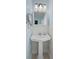 Bathroom featuring pedestal sink, mirrored medicine cabinet, and soft blue walls at 113 N Munsie St, Indianapolis, IN 46229